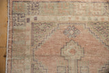 Original side cord selvage with geometric pattern and distressed apricot, green, mauve pile.