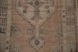 Distressed geometric stepped design on vintage Oushak rug in apricot, mauve, and seafoam green.