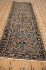 Distressed Lilihan rug corner detail, dusty mauve field, floral blossoms, and navy meandering border.