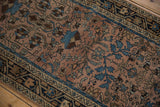 Distressed dusty mauve field with blue floral blossoms and navy geometric border.