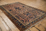 Distressed Lilihan rug's meandering vine border, dusty rose field, and floral motifs.