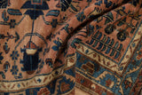 Vintage Lilihan rug's distressed pile texture, dusty rose field, navy vine border.