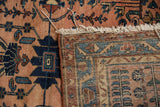 Distressed dusty rose and navy floral motifs on Lilihan pile with woven border and fringe.