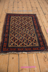 Belouch rug corner, featuring the camel, red, and blue pawn border with fringed end.