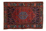 Hand-knotted vintage Borchalou rug, cherry red field, sapphire blue Herati medallion, geometric border.