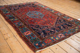 Vintage Borchalou rug corner, highlighting wide geometric floral border in ruby red and sapphire blue.