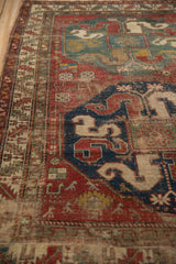 Antique Caucasian rug, geometric cloudband motif in navy, cherry red, beige, showing wear.