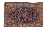 Vintage Northwest Persian rug with asymmetric navy blue medallion, stepped finials, blush and ivory floral field.