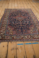 Traditional Northwest Persian rug's navy blue floral field and intricate ivory border.