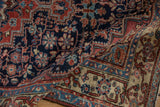 Navy, faded blush, and ivory floral blossoms on the folded vintage Northwest Persian rug.