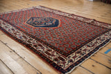 Angled perspective of the vintage Serbend rug's stepped medallion and repeating field pattern.
