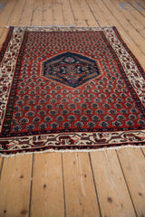 Angled perspective of a vintage Serbend rug's stepped medallion and brick red field.