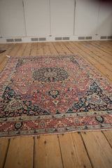 Intricate vinery and blossoms detail on this vintage Meshed rug, featuring dusty red and navy tones.