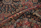 Folded vintage Meshed rug, intricate vinery and blossoms in dusty red, navy, sky blue.