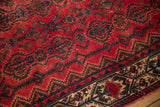 Distressed texture on raspberry red Borchalou field with navy serrated floral cartouches.