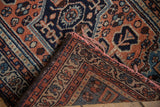 Folded edge of vintage Borchalou rug shows red-tinted fringe and woven foundation.