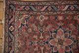 Dargezine rug corner: meandering leaf and floral border, dusty burgundy, navy, and intact selvage.