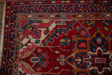 Multi-colored pearl border of the Vintage Heriz rug, showing gem-tone reds, navies, and ivory fringe.