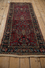 Detail of the vintage Lilihan runner's cherry red field with floral vinery and navy border.