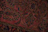 Close-up of vintage Lilihan rug, dusty raspberry field, ornate navy and gold patterns, even wear.