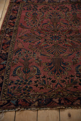 Dusty raspberry Lilihan rug: ornate navy, gold, and powder blue paisley plant motifs.