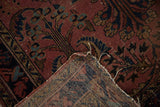 Vintage Lilihan rug corner: hand-knotted foundation, tattered edge, dusty raspberry motifs.