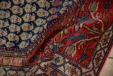Original side cord selvage separating the navy boteh field from the tomato red floral border.