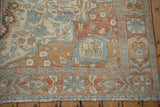 Distressed Malayer carpet corner, showing faded madder red pomegranate border and blue floral motifs.