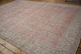 Distressed pink and beige pile of the vintage Sparta carpet, showing faded scrolling vinery.