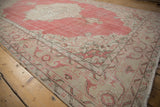 Curvilinear blush and beige patterns with distressed texture on a Turkish Sparta rug corner.