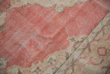Distressed blush field and curvilinear beige pattern with visible wear on this Sparta carpet.