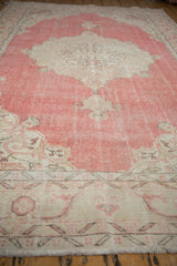Distressed vintage Turkish Sparta carpet, showing worn blush field and beige geometric border.