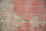 Detail of distressed vintage Sparta carpet: blush and ivory arabesque pattern with visible wear.