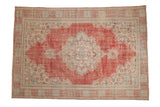 Vintage distressed Oushak carpet with faded cherry red, ivory medallion, turquoise florals.