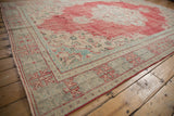 Faded cherry red and antique ivory distressed Oushak border with geometric motifs.