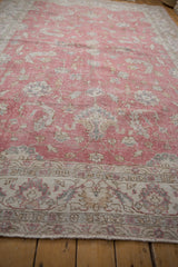 Distressed vintage Sparta carpet: mostly even wear revealing foundation and intricate floral border with pale coffee brown, slate, and dusty raspberry.