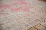 Vintage Distressed Sparta carpet close-up, showcasing worn bubblegum pink and beige traditional pattern.