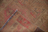 Distressed vintage Kurd runner showing low pile with visible knot heads and blue stitched edge.