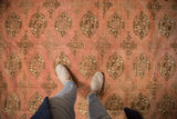 Plush, distressed vintage Bokhara carpet with coffee brown guls on dusty rose field.