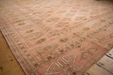 Pink and coffee brown geometric gul motifs with abrash on a distressed Bokhara rug.