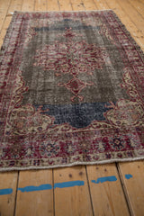 Textural bottom edge of a distressed vintage Sparta rug, with cherry red and cobalt blue.