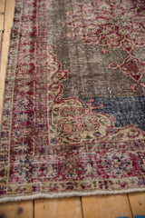 Distressed vintage Sparta rug pile showing textured dark cherry, ivory, cobalt motifs on oxidized silver field.