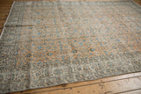 Worn pale apricot Sparta carpet showing indigo floral patterns and intricate border.