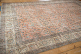 Patina on the intricate ivory border and faded terracotta field of a vintage Sparta carpet.