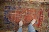 Distressed terracotta prayer field with vibrant royal blue-purple border and floral motifs.