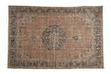 Distressed vintage Sparta carpet, medallion, faded tan field, dusty blue floral patterns.
