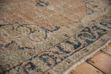 Distressed Turkish Sparta carpet border with faded antique ivory, dusty navy, and seafoam green floral details.