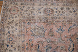 Faded navy and pink Herati floral motifs, visible knot heads on distressed Sparta rug.