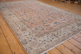 Distressed vintage Sparta rug showing visible wear, faded pink field, and intricate border design.