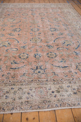 Distressed edge of the Vintage Sparta carpet, showing wear, faded pink, beige, and blue Herati motifs.
